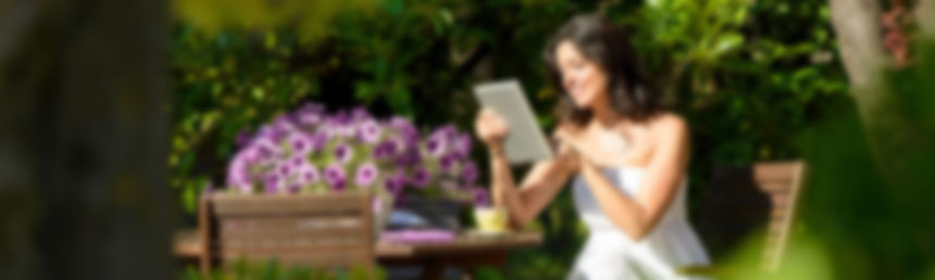 Frau mit Tablet im Frühlingsgarten